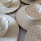 verschieden dekorierte Schälchen auf Tellern in Weiß/ Beigetönen der Keramikerin Uta Minnich